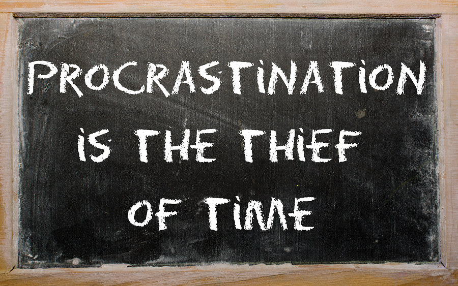 Proverb "procrastination Is The Thief Of Time" Written On A Blac