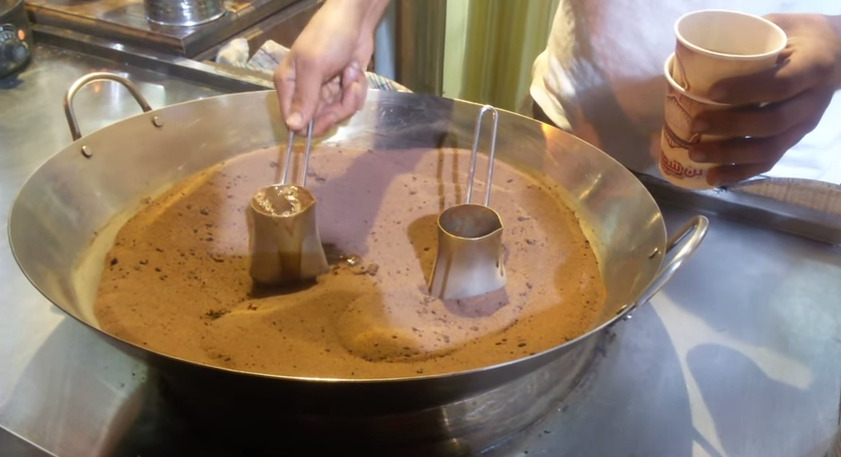 Making coffee on the sand close up, turkish coffee on a market